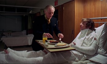 Movie still from “A Clockwork Orange” (1971), directed by Stanley Kubrick – An older gentleman serving breakfast to an older man in a hospital bed; Medium shot, High angle