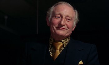 Movie still from “A Clockwork Orange” (1971), directed by Stanley Kubrick – An older man wearing a suit and a tie; Close Up shot, Low angle
