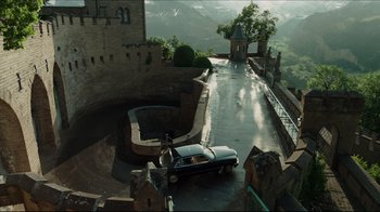 Movie still from “A Cure for Wellness” (2016), directed by Gore Verbinski – A car parked on the side of a road near a castle; Extreme Wide shot, High angle