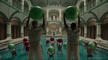 Movie still from “A Cure for Wellness” (2016), directed by Gore Verbinski – A group of people standing in a pool holding balls; Wide shot, Low angle