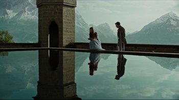 Movie still from “A Cure for Wellness” (2016), directed by Gore Verbinski – A man and a woman sitting on a ledge near a pool of water; Wide shot, Low angle