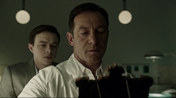 Movie still from “A Cure for Wellness” (2016), directed by Gore Verbinski – A man and a boy looking at something on a table; Close Up shot, Low angle