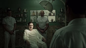 Movie still from “A Cure for Wellness” (2016), directed by Gore Verbinski – A man sitting in front of another man in a room; Medium shot, Low angle