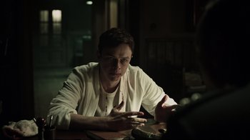 Movie still from “A Cure for Wellness” (2016), directed by Gore Verbinski – A man sitting at a table with a cell phone in his hand; Medium shot, Over the shoulder angle