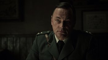 Movie still from “A Cure for Wellness” (2016), directed by Gore Verbinski – A man in a military uniform is looking at the camera; Close Up shot, Low angle