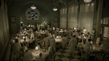 Movie still from “A Cure for Wellness” (2016), directed by Gore Verbinski – A group of people sitting at tables in a large room; Wide shot, High angle