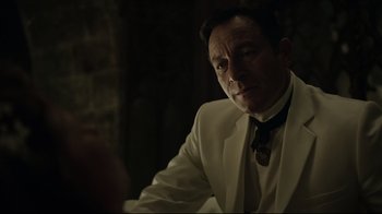 Movie still from “A Cure for Wellness” (2016), directed by Gore Verbinski – A man in a white suit sitting at a table in front of a brick wall; Close Up shot, Over the shoulder angle