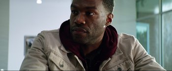 Movie still from “Ambulance” (2022), directed by Michael Bay – A person wearing a jacket; Close Up shot, Over the shoulder angle