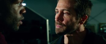 Movie still from “Ambulance” (2022), directed by Michael Bay – A person with a beard; Close Up shot, Over the shoulder angle