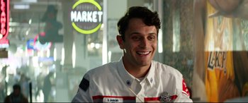 Movie still from “Ambulance” (2022), directed by Michael Bay – A man in a uniform smiling for the camera; Close Up shot, Over the shoulder angle