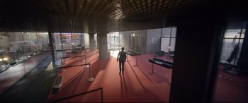 Movie still from “Ambulance” (2022), directed by Michael Bay – A man walking in an empty room in a building; Extreme Wide shot, High angle