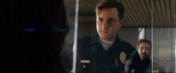 Movie still from “Ambulance” (2022), directed by Michael Bay – A man in a police uniform looking at a mirror; Close Up shot, Low angle