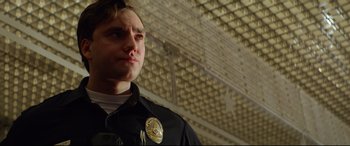 Movie still from “Ambulance” (2022), directed by Michael Bay – A man in a police uniform looking to his left; Close Up shot, Low angle