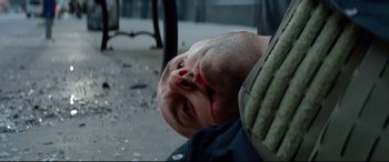Movie still from “Ambulance” (2022), directed by Michael Bay – A man laying on the ground with blood all over his face; Close Up shot, Low angle
