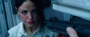 Movie still from “Ambulance” (2022), directed by Michael Bay – A woman is looking at the camera while holding a gun; Close Up shot, Low angle