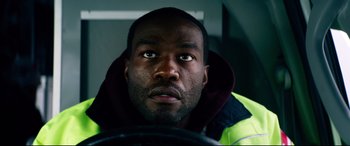 Movie still from “Ambulance” (2022), directed by Michael Bay – A person wearing a yellow jacket; Close Up shot, Low angle