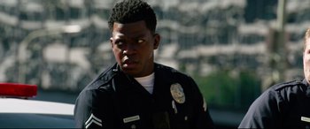 Movie still from “Ambulance” (2022), directed by Michael Bay – A police officer is looking into the distance; Close Up shot, Over the shoulder angle