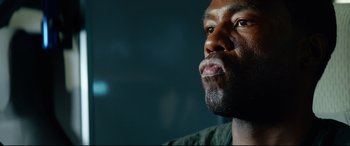 Movie still from “Ambulance” (2022), directed by Michael Bay – A man's face in a dark room; Close Up shot, Low angle