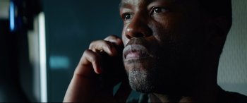 Movie still from “Ambulance” (2022), directed by Michael Bay – A person talking on a cell phone; Close Up shot, Low angle