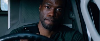 Movie still from “Ambulance” (2022), directed by Michael Bay – A person with a car steering wheel; Close Up shot, Overhead angle