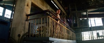 Movie still from “Ambulance” (2022), directed by Michael Bay – A man standing on top of a metal railing; Wide shot, Low angle