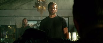 Movie still from “Ambulance” (2022), directed by Michael Bay – A person standing in a room; Medium shot, Over the shoulder angle