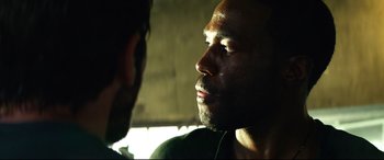 Movie still from “Ambulance” (2022), directed by Michael Bay – A man looking into the distance while another man looks at him; Close Up shot, Over the shoulder angle