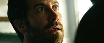 Movie still from “Ambulance” (2022), directed by Michael Bay – A man with a beard looking up; Close Up shot, Low angle