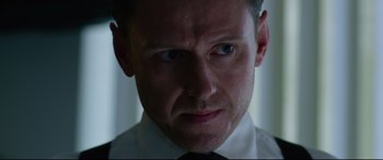 Movie still from “Ambulance” (2022), directed by Michael Bay – A person wearing a shirt and tie; Close Up shot, Low angle