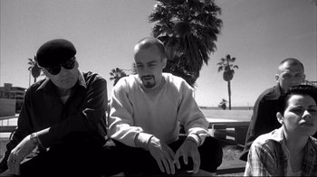 Movie still from “American History X” (1998), directed by Tony Kaye – A man sitting on the ground next to another man; Medium shot, Over the shoulder angle