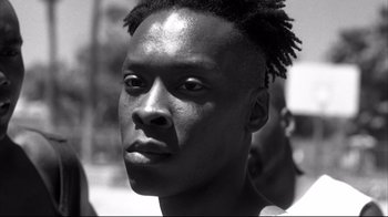 Movie still from “American History X” (1998), directed by Tony Kaye – A black and white photo of a man with a dreadlocks; Close Up shot, Low angle