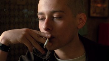 Movie still from “American History X” (1998), directed by Tony Kaye – A man smoking a cigarette while wearing a jacket; Close Up shot, Low angle