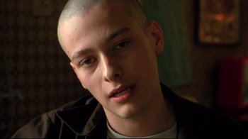 Movie still from “American History X” (1998), directed by Tony Kaye – A man with a shaved head is looking at the camera; Close Up shot, Low angle