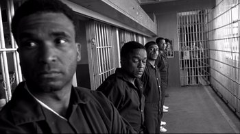 Movie still from “American History X” (1998), directed by Tony Kaye – A black and white photo of a group of men standing next to each other; Medium shot, Low angle