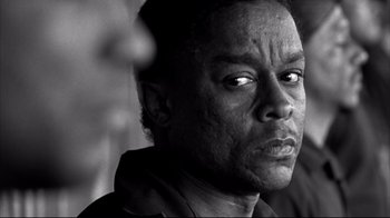 Movie still from “American History X” (1998), directed by Tony Kaye – A black - and - white photo of a man looking into the distance; Close Up shot, Low angle