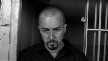 Movie still from “American History X” (1998), directed by Tony Kaye – Black and white photograph of a man with a shaved head; Close Up shot, Low angle