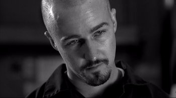 Movie still from “American History X” (1998), directed by Tony Kaye – Black and white photograph of a man with a shaved head; Close Up shot, Low angle