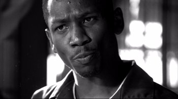 Movie still from “American History X” (1998), directed by Tony Kaye – A black and white photo of a man looking at the camera; Close Up shot, Low angle