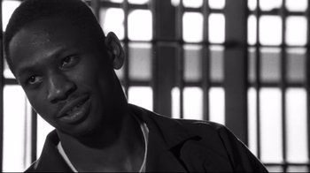 Movie still from “American History X” (1998), directed by Tony Kaye – A black and white photo of a man smiling; Close Up shot, Over the shoulder angle