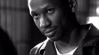 Movie still from “American History X” (1998), directed by Tony Kaye – A black and white photo of a man looking at the camera; Close Up shot, Low angle
