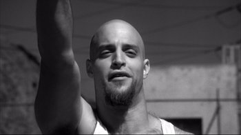 Movie still from “American History X” (1998), directed by Tony Kaye – A bald man with a beard raising his hand; Close Up shot, Low angle