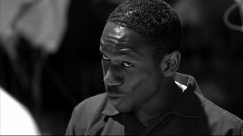 Movie still from “American History X” (1998), directed by Tony Kaye – A black and white photo of a man looking at the camera; Close Up shot, Low angle