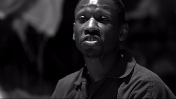 Movie still from “American History X” (1998), directed by Tony Kaye – A black and white photo of a man looking at the camera; Close Up shot, Low angle