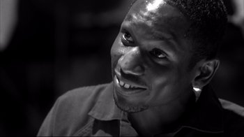 Movie still from “American History X” (1998), directed by Tony Kaye – A black and white photo of a man smiling; Close Up shot, Low angle