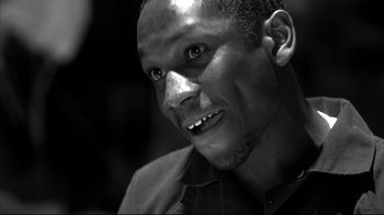 Movie still from “American History X” (1998), directed by Tony Kaye – A black and white photo of a man smiling; Close Up shot, Low angle
