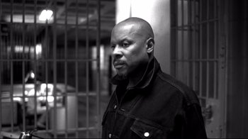 Movie still from “American History X” (1998), directed by Tony Kaye – A black and white photo of a man in front of bars; Close Up shot, Low angle