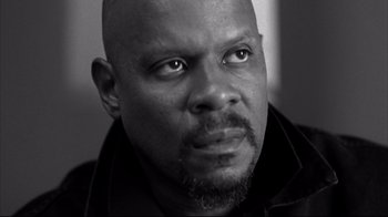 Movie still from “American History X” (1998), directed by Tony Kaye – A black and white photo of a man with a goatee; Close Up shot, Low angle