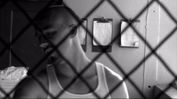 Movie still from “American History X” (1998), directed by Tony Kaye – A man standing in front of a chain link fence; Close Up shot, Low angle