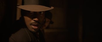 Movie still from “Amsterdam” (2022), directed by David O. Russell – A person wearing a hat; Close Up shot, Over the shoulder angle