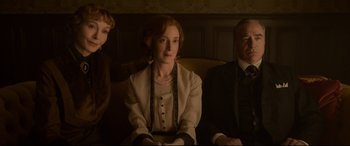 Movie still from “Amsterdam” (2022), directed by David O. Russell – A woman sitting next to a man and a boy; Medium shot, High angle